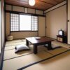 座布団と座卓が置かれた来客用の和室。床の間には壺が飾られている。/ A guest tatami room with cushions and a low table, featuring a decorative vase in the tokonoma alcove.