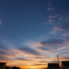 夕暮れ時、家屋や電柱が並ぶ町の風景と美しいグラデーションの空。 / A townscape at dusk with houses, utility poles, and a beautifully graded sky.