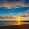 夕日が海と砂浜を優しく照らす、空とのバランスが美しい海辺の風景。 / A beautiful seaside view where the sunset gently lights the sea and beach, harmonizing with the sky.