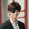 黒い片目の眼帯を着けて笑顔を見せる若い男性。 / A young man smiling while wearing a black one-eyed eyepatch.