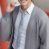 グレーのカーディガンを羽織って微笑む若い男性 / A young man smiling in a gray cardigan