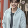 水色のパーカーを着て笑顔を見せる若い男性 / A young man smiling in a light blue hoodie