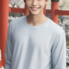 水色の長袖Tシャツを着て笑顔を見せる若い男性 / A young man smiling in a light blue long-sleeve T-shirt