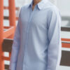 水色のワイシャツを着て笑顔を見せる若い男性 / A young man smiling in a light blue dress shirt
