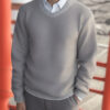 グレーのセーターを着て笑顔を見せる若い男性 / A young man smiling in a gray sweater