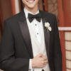 黒いタキシードを着て笑顔を見せる若い男性 / A young man smiling in a black tuxedo