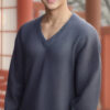 Vネックのネイビーセーターを着て笑顔を見せる若い男性 / A young man smiling in a navy V-neck sweater