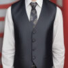 ネクタイとベスト姿で笑顔を見せる若い男性 / A young man smiling in a necktie and vest outfit
