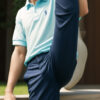 "片足を高く上げてポーズをとるポロシャツ姿の少年 / a boy in a polo shirt posing with one leg raised high"