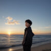 朝焼けの海を見つめる少年の横顔 / Side view of a boy gazing at the sea during sunrise