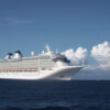 青空の下、白いクルーズ船が静かな海を航行している / White cruise ship sailing calmly under a blue sky