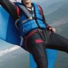 カラフルなパラグライダーに乗って青空を飛ぶ青年、風を感じる笑顔 A young man flying through the blue sky on a colorful paraglider, smiling in the breeze