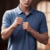Young man in a blue polo shirt clenching his fists with a determined expression indoors （青いポロシャツを着た若い男性が室内で決意に満ちた表情でこぶしを握っている）