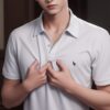 Young man in a white polo shirt lightly clutching his chest with both hands, standing indoors with a calm expression （白いポロシャツを着た若い男性が室内で穏やかな表情を浮かべながら両手で胸元を軽く押さえている）