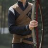 弓を持って微笑むアーチェリーウェアの青年、屋外の芝生でポーズ A young man in archery wear smiling while holding a bow, posing on a grassy outdoor field