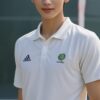 バドミントンコートの前で白いユニフォームを着て立つ青年、爽やかな表情 A young man in a white badminton uniform standing in front of the court with a fresh expression