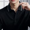 Young man in a black polo shirt gently holding a chess piece over the board, contemplating his next move （黒のポロシャツを着た若い男性がチェス盤の上で駒を慎重につまみ、次の手を考えている）
