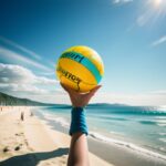 片手で黄色いビーチボールを掲げ、砂浜と海を見渡す構図 / A yellow beach ball held high in one hand, overlooking the beach and sea