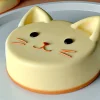 丸いフォルムと立ち耳が可愛い猫型チーズケーキ、優しい色合いが魅力 Cat-shaped cheesecake with round form and upright ears, featuring a soft and gentle color tone
