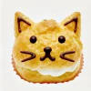猫の顔をかたどったシュークリーム、チョコで描かれた目とひげがキュート Cream puff shaped like a cat face, with chocolate-drawn eyes and whiskers adding cuteness