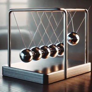 金属フレームのニュートンのゆりかごがデスク上に置かれ、球が今にも動き出しそうな構図 Newton's cradle with metal frame placed on a desk, with a ball poised for motion