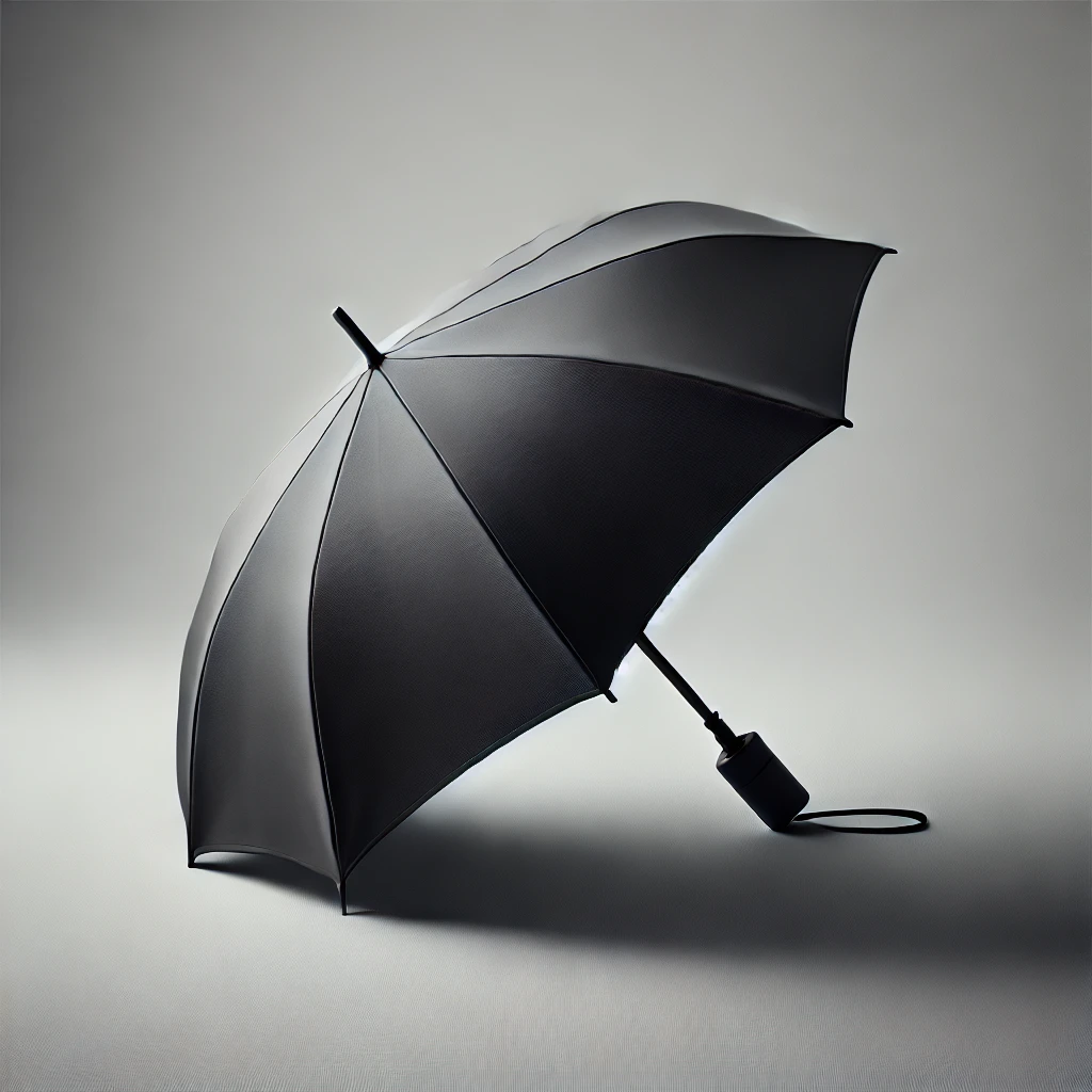 グレーの背景に置かれたシンプルな黒い折りたたみ傘 A simple black compact umbrella placed against a gray background
