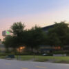 夕暮れ時の病院の外観と周囲の木々 Exterior view of a hospital surrounded by trees at dusk