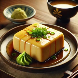 とろみのあるだし醤油がかかった玉子豆腐に青ねぎとわさびを添えた一品
Japanese egg tofu topped with green onions and wasabi in savory soy-based sauce